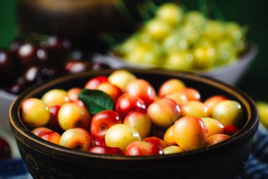 Masadaki kiraz tabağında bir sürü farklı renk var.