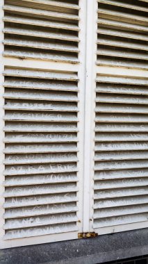 Üzerinde başlıklar olan beyaz pencere panjurları.