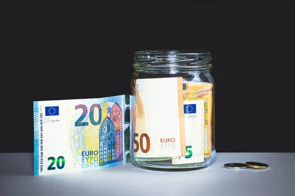 Bir kavanozda 20 Euro 'luk banknot ve sikkelerin yanına istiflenmiş Euro banknotları..