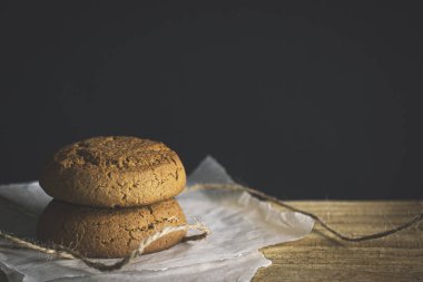 Jüt halatla bağlanmış bir kalasta üst üste iki kurabiye. Ev yapımı, fotokopi alanı olan sanat fotoğrafı.