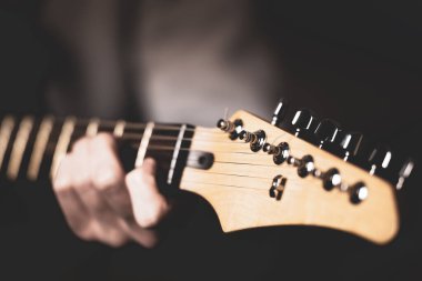 Elektro gitar çalan bir adam, eli ve parmaklarıyla yakın plan..