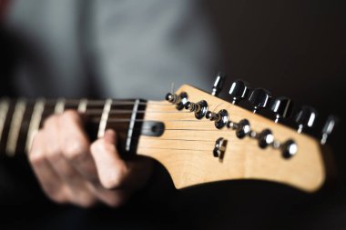 Elektro gitar çalan bir adam, eli ve parmaklarıyla yakın plan..