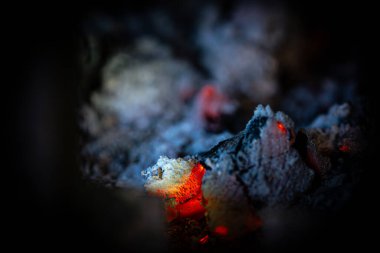 Kamp ateşinde yanan közler. Yakın plan, doğal soyut arka plan..