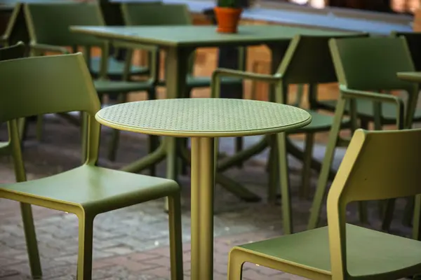 Sabahın erken saatlerinde bir kafede boş plastik sandalyeler ve masalar. İki kişilik masa..