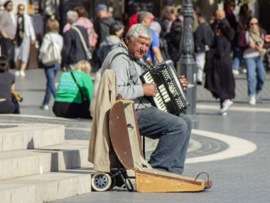 Müzisyen sokak gitarını şehrin meydanında çalıyor. Caddenin ortasında, Madrid şehrinin merkezinde..
