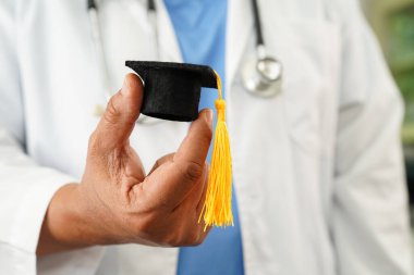  Asyalı doktor mezuniyet şapkası ve eğitim ilacı taşıyor..