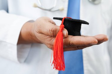  Asyalı doktor mezuniyet şapkası ve eğitim ilacı taşıyor..