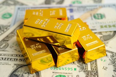 Gold bar on US dollar banknotes, finance and economy. 