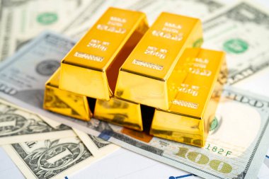 Gold bar on US dollar banknotes, finance and economy.