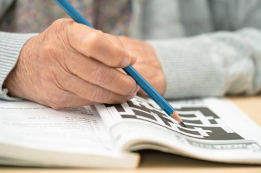 Alzheimer hastalığı AD, bunama için sudoku bulmacası oynayan Asyalı yaşlı kadın.