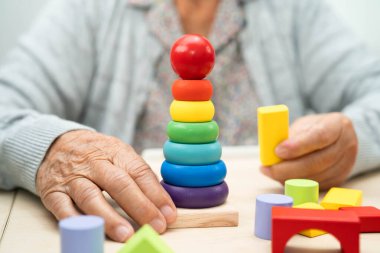 Alzheimer hastalığı AD, bunama geçiren Asyalı yaşlı kadın hasta pratik motor beceri rehabilitasyonu öğreniyor.