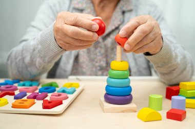 Alzheimer hastalığı AD, bunama geçiren Asyalı yaşlı kadın hasta pratik motor beceri rehabilitasyonu öğreniyor.