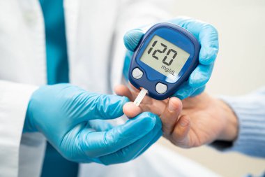Doctor use digital glucose monitor measure and test stripe for check diabetes from finger blood sugar level.