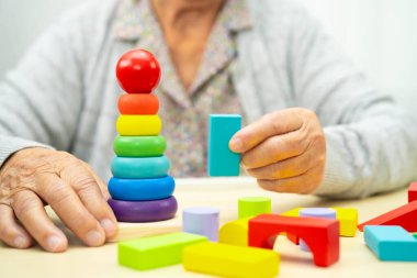 Alzheimer hastalığı AD, bunama geçiren Asyalı yaşlı kadın hasta pratik motor beceri rehabilitasyonu öğreniyor.