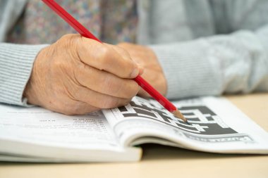 Bangkok, Tayland 1 Haziran 2024 Alzheimer Hastalığı AD, bunama için sudoku oyunu oynayan Asyalı yaşlı kadın.