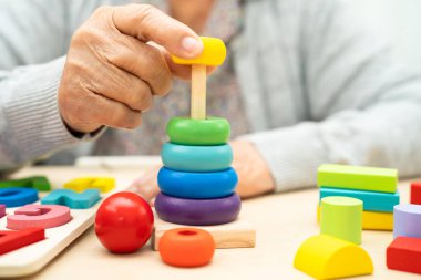 Alzheimer hastalığı AD, bunama geçiren Asyalı yaşlı kadın hasta pratik motor beceri rehabilitasyonu öğreniyor.