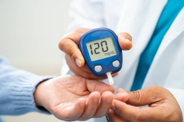Doctor use digital glucose monitor measure and test stripe for check diabetes from finger blood sugar level.