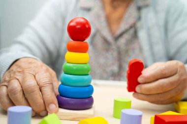 Alzheimer hastalığı AD, bunama geçiren Asyalı yaşlı kadın hasta pratik motor beceri rehabilitasyonu öğreniyor.