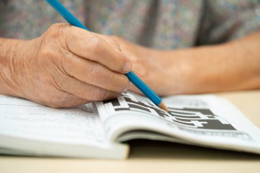 Alzheimer Hastalığı AD, Asyalı yaşlı kadın sudoku bulmaca oyunu oynuyor.