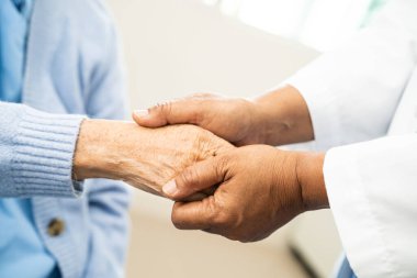 Doktor el ele tutuşup hastanedeki yaşlı kadına yardım ediyor..