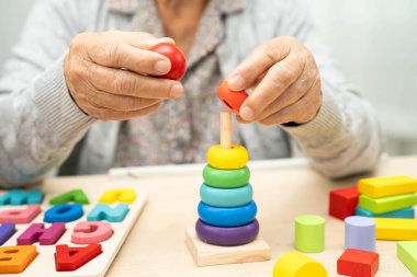 Alzheimer hastalığı AD, bunama geçiren Asyalı yaşlı kadın hasta pratik motor beceri rehabilitasyonu öğreniyor.