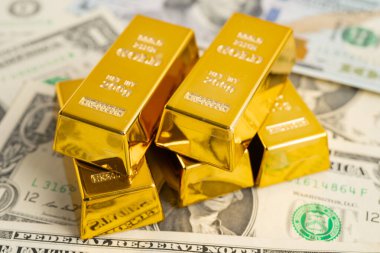 Gold bar on US dollar banknotes, finance and economy.