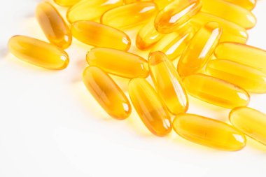 Beyaz arka planda EPA ve DHA içeren Omega 3 vitamini balık yağı kapsülleri.