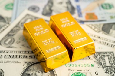 Gold bar on US dollar banknotes, finance and economy.
