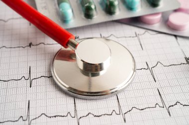 Kırmızı kalp ve uyuşturucu, kalp dalgası, kalp krizi, kardiyogram raporu ile elektrokardiyogram (ECG) üzerinde stetoskop.