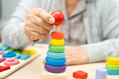 Alzheimer hastalığı AD, bunama geçiren Asyalı yaşlı kadın hasta pratik motor beceri rehabilitasyonu öğreniyor.