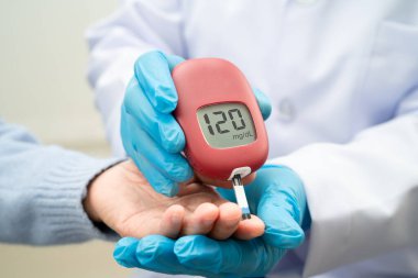 Doctor use digital glucose monitor measure and test stripe for check diabetes from finger blood sugar level.