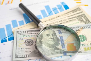 Grafikte Amerikan doları banknotları olan büyüteç. Finans ve ticaret.