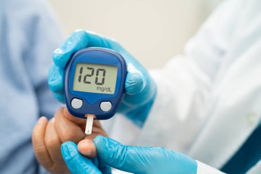 Doctor use digital glucose monitor measure and test stripe for check diabetes from finger blood sugar level.