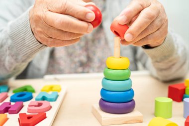 Alzheimer hastalığı AD, bunama geçiren Asyalı yaşlı kadın hasta pratik motor beceri rehabilitasyonu öğreniyor.