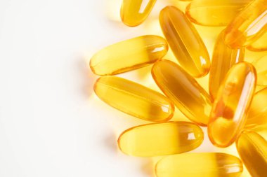 Beyaz arka planda EPA ve DHA içeren Omega 3 vitamini balık yağı kapsülleri.