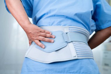 Asya baş ağrısı. Esnek destek kemeri takıp yürüteç takıyor..