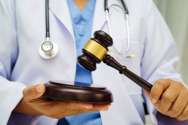 Asyalı doktor, adli tıp ve suç hukuku için çekiç tutuyor..