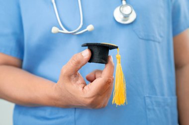 Hastanede elinde mezuniyet şapkası olan Asyalı kadın doktor. Tıp eğitimi konsepti..