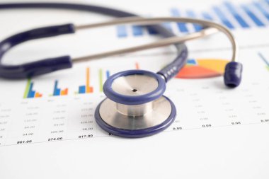 Çizelge ya da grafik kağıdı, Finansal, hesap, istatistik ve iş verileri medikal sağlık kavramı üzerine steteskop ve ABD doları banknotları.