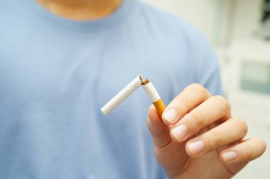 Sigarayı bırak, Asyalı adam kırıyor sigarayı elinde yok et.