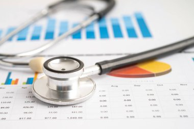 Çizelge ya da grafik kağıdı, Finansal, hesap, istatistik ve iş verileri medikal sağlık kavramı üzerine steteskop ve ABD doları banknotları.