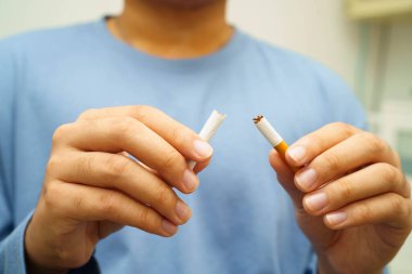 Sigarayı bırak, Asyalı adam kırıyor sigarayı elinde yok et.