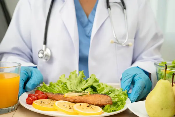 Asyalı Beslenme Uzmanı hastalar için sağlıklı yiyecekler, beslenme ve vitamin tutuyor..