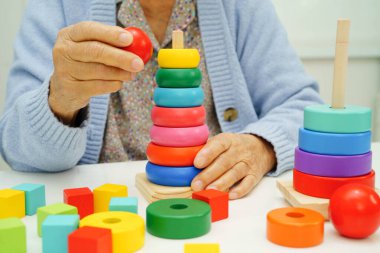 Asyalı yaşlı bir kadın, geliştirme oyunu oynuyor..