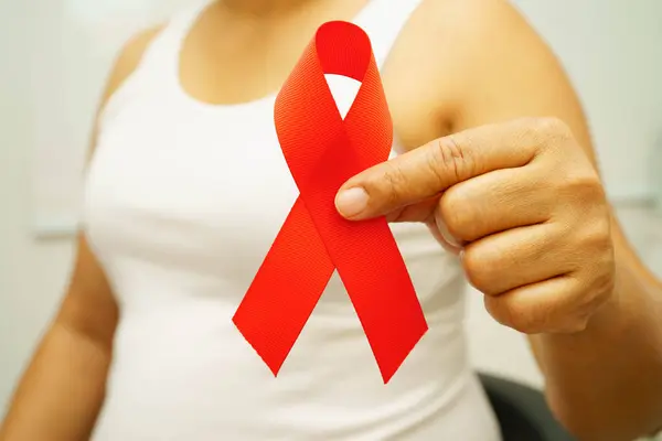 Aralık ayı AIDS günü için kırmızı kurdeleli Asyalı kadın. AIDS ve HIV farkındalığı.