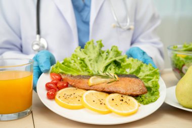 Asyalı Beslenme Uzmanı hastalar için sağlıklı yiyecekler, beslenme ve vitamin tutuyor..