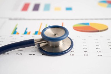 Çizelge ya da grafik kağıdı, Finansal, hesap, istatistik ve iş verileri medikal sağlık kavramı üzerine steteskop ve ABD doları banknotları.