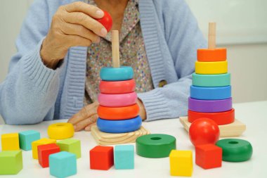 Asyalı yaşlı bir kadın, geliştirme oyunu oynuyor..