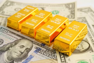 Gold bars on US dollar banknote money, finance trading investment business currency concept.