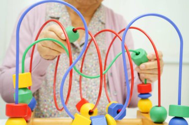 Asyalı yaşlı bir kadın, geliştirme oyunu oynuyor..